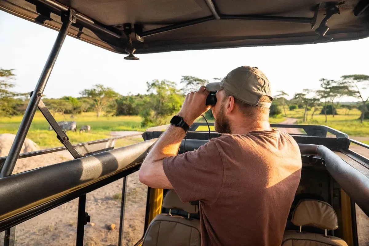 Mit dem Fernglas im offenen Safarifahrzeug