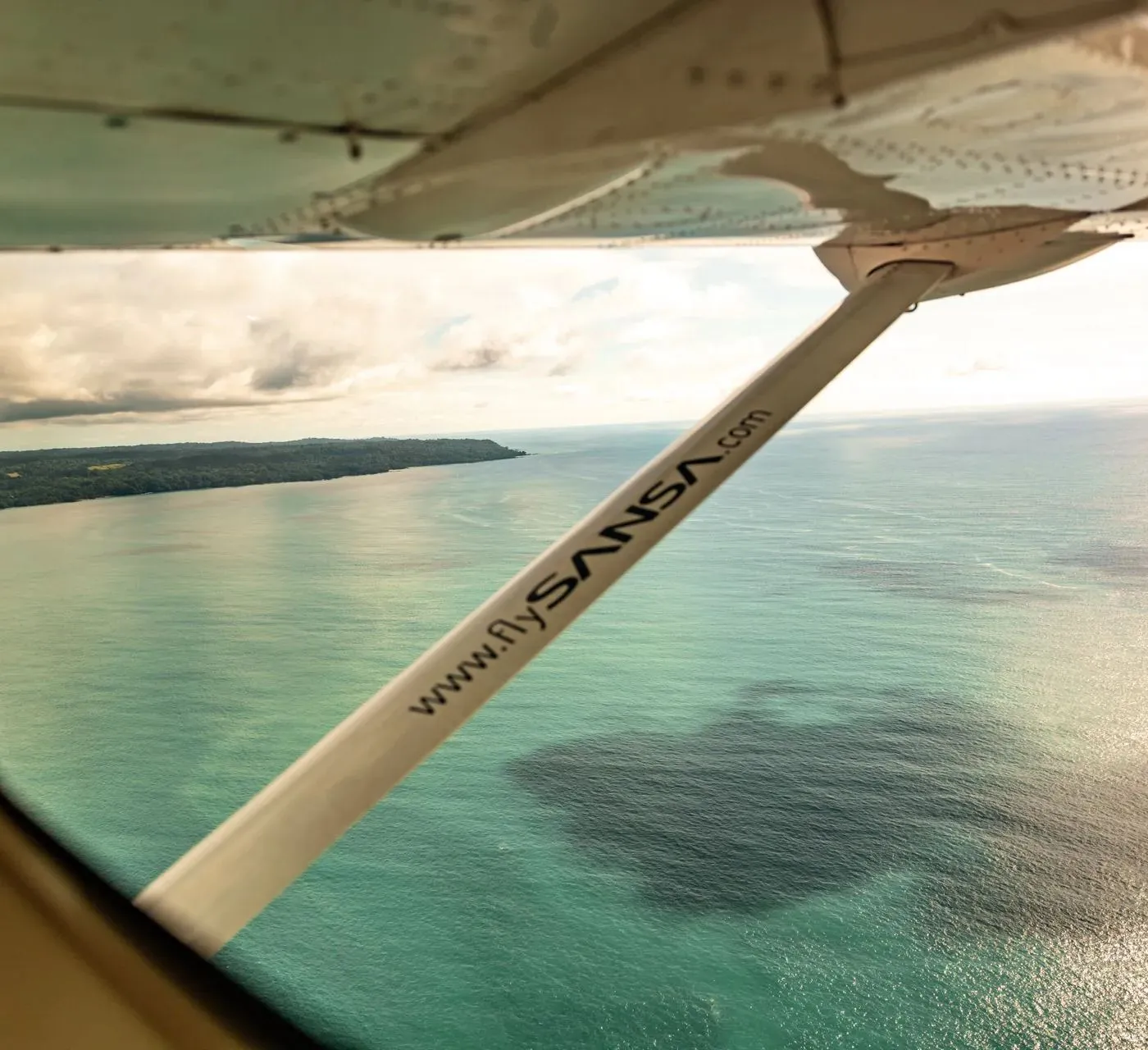 Aus dem Flugzeug auf Küste und türkises Wasser