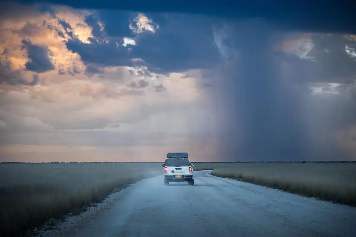 Fahrzeug auf der Piste unter einer aufziehenden Regenwand